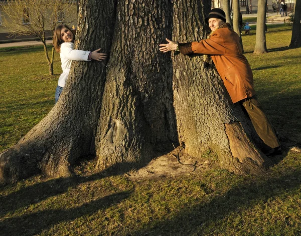 Hija y abuelita abrazar árbol gigante — Foto de Stock