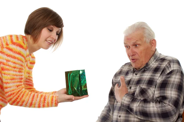 Счастливый дедушка и внучка с подарком — стоковое фото