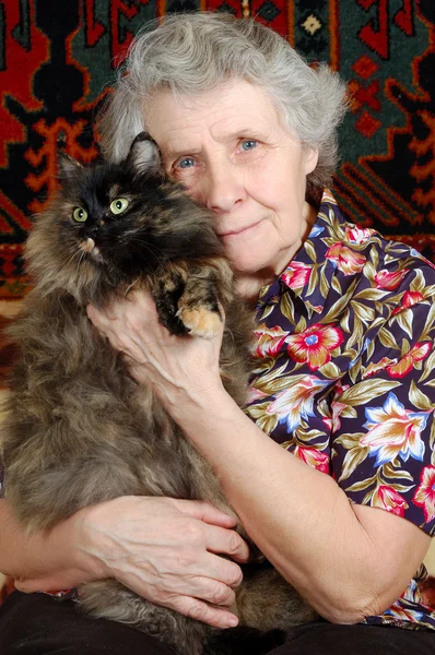 Γιαγιά κάθεται με γάτα επάνω τα χέρια της — Φωτογραφία Αρχείου