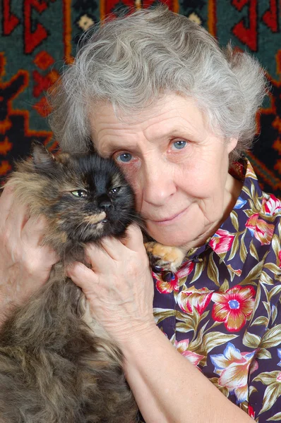 Grootmoeder zitten met kat op haar handen — Stockfoto