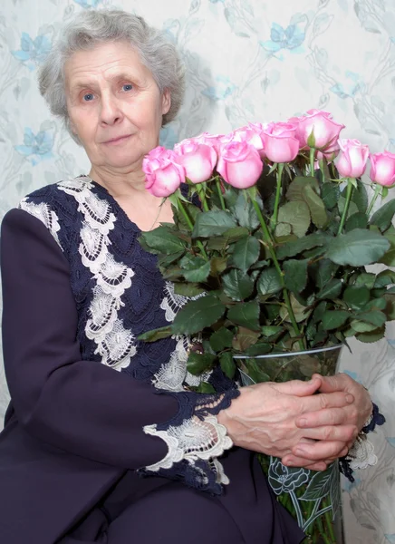 奶奶背后的粉红色的玫瑰花束 — 图库照片