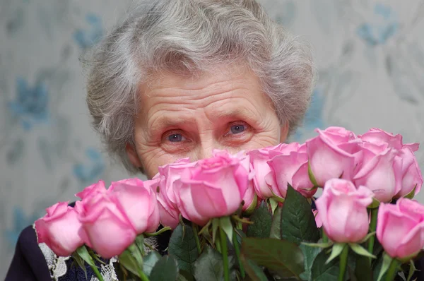 ピンクのバラの花束の背後にある幸せなおばあちゃん — ストック写真