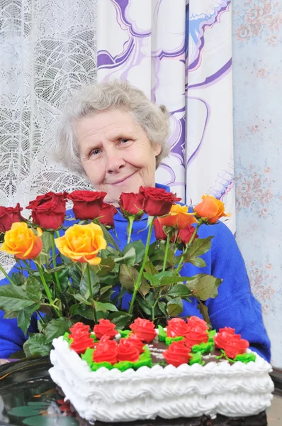 Elderly woman with roses — Stock Photo, Image