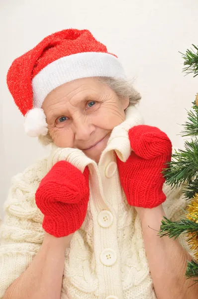 赤いサンタ クロースの帽子と赤のミトンの老婦人 — ストック写真
