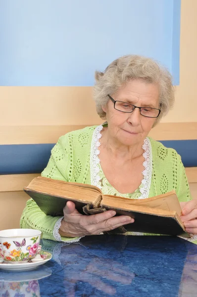 Yaşlı kadın bir kitap okumak için — Stok fotoğraf