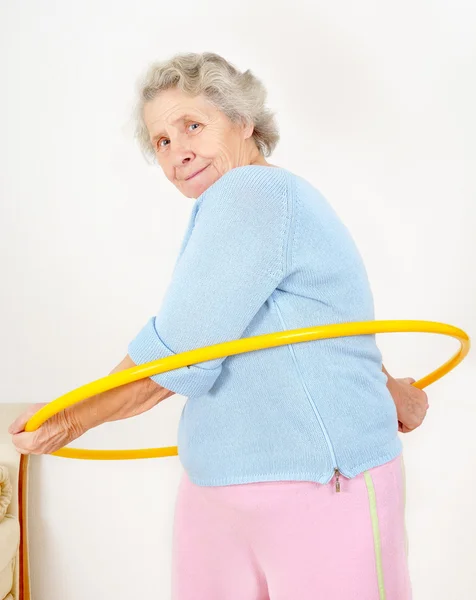 Portrait senior lady doing gymnastic with hula-hoop — Stock Photo, Image