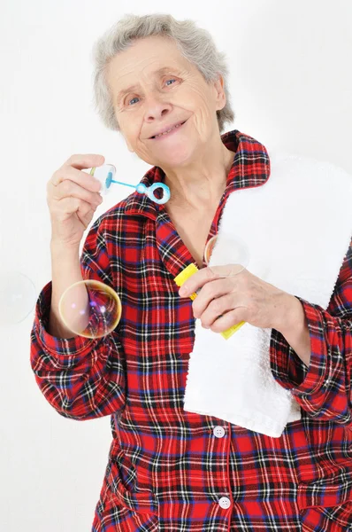 Senior lady blowing soap bubbles — Stock Photo, Image