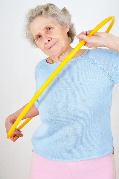 Anziana signora facendo ginnastica con hula-hoop — Foto Stock