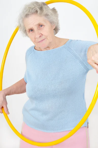 Старшая леди занимается гимнастикой с хула-хупом — стоковое фото