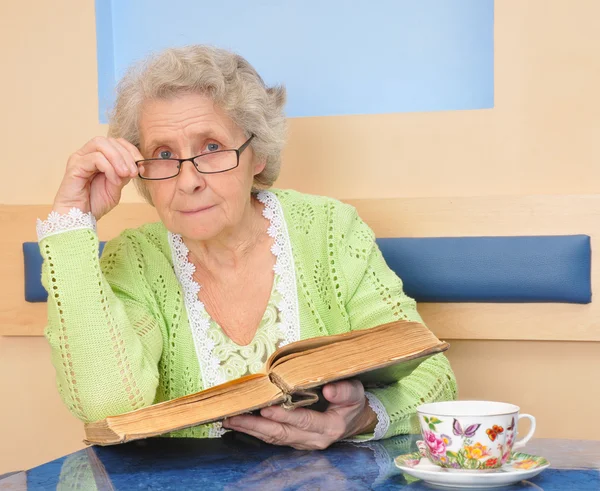Seniorin mit Buch in der Hand — Stockfoto
