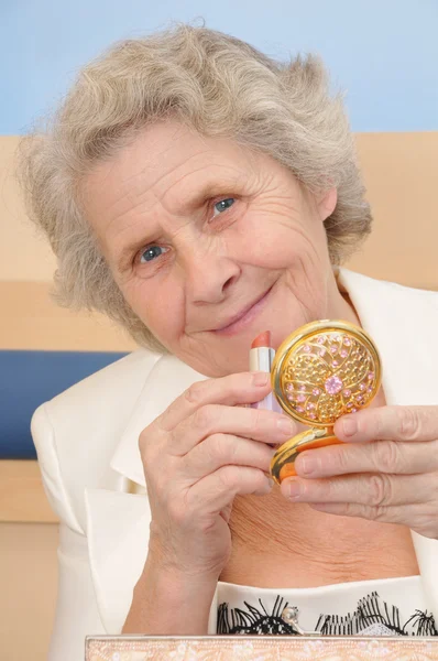 Senior lady with lipstick and mirror — Stock Photo, Image