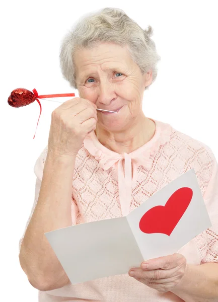 Femme âgée tenir carte postale avec la forme du cœur sur elle couverture — Photo