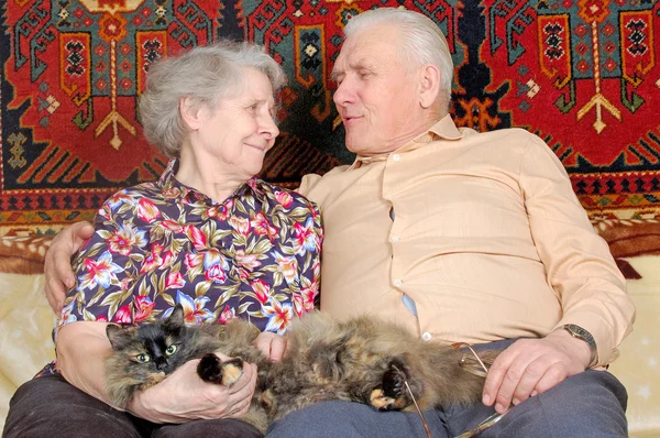 Ευτυχισμένο ζευγάρι εβδομήντα χρονών με γάτα — Φωτογραφία Αρχείου