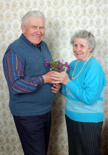 自然の花を持つ幸せな老夫婦 — ストック写真