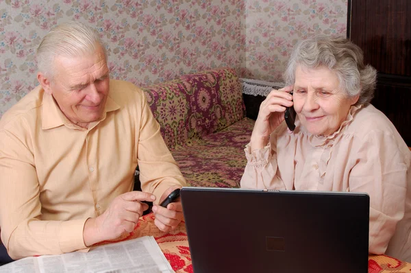 Äldre par skvaller om något via telefon — Stockfoto