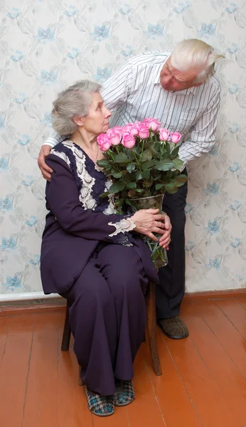 Velho casal e grande buquê de rosas rosa — Fotografia de Stock
