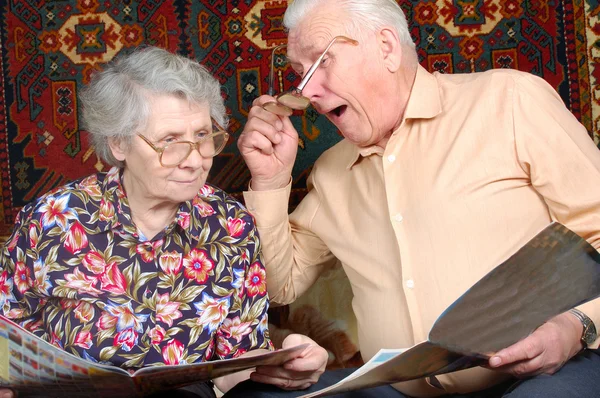 Seniorenpaar liest Nachrichten und lächelt — Stockfoto