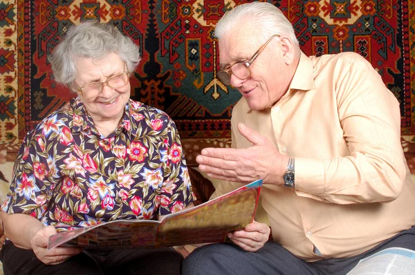 Pareja de ancianos leer las noticias y sonreír — Foto de Stock