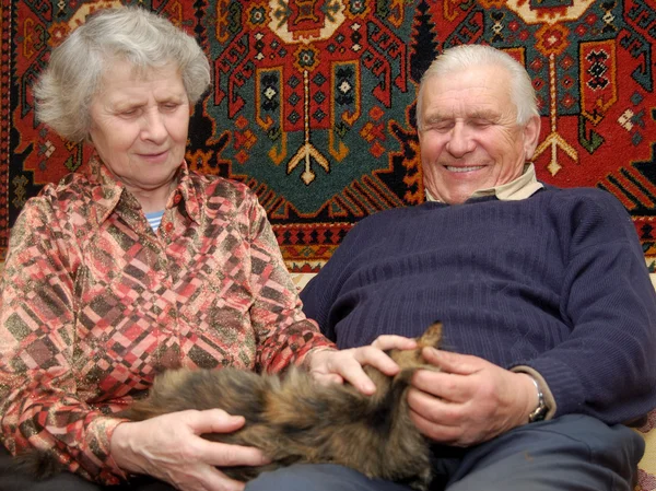 Settanta anni coppia sorridente in casa sul divano — Foto Stock