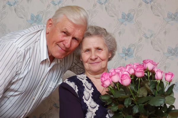 Lyckliga gamla paret och bouqet av rosor — Stockfoto