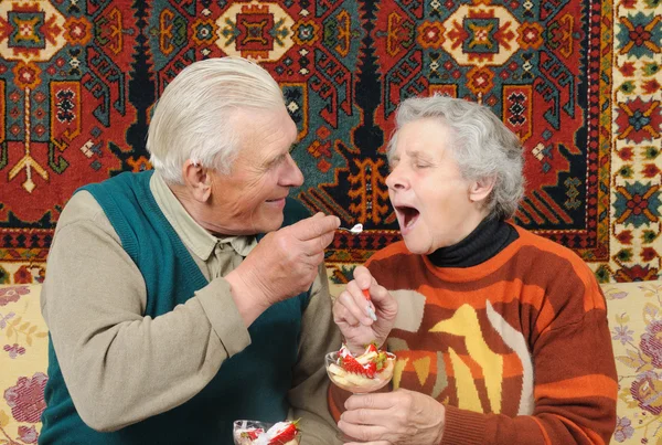 Grootvader en grootmoeder eten strawberrys — Stockfoto