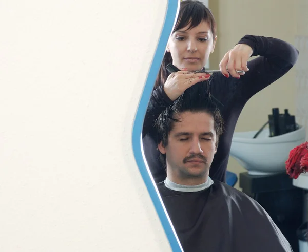 Il barbiere al lavoro. vista dallo specchio — Foto Stock