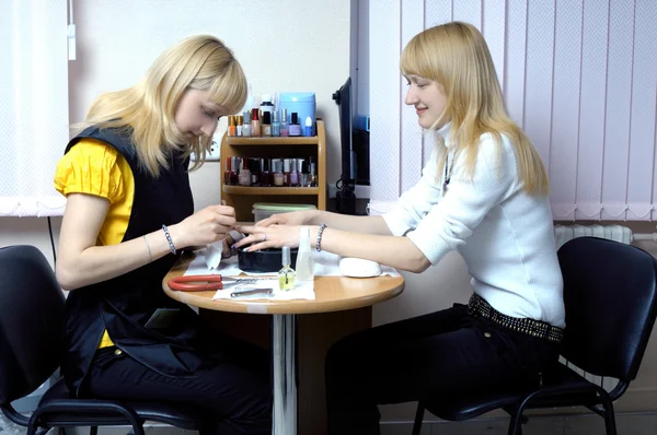 Two attractive blond girls making manicure — Stock Photo, Image