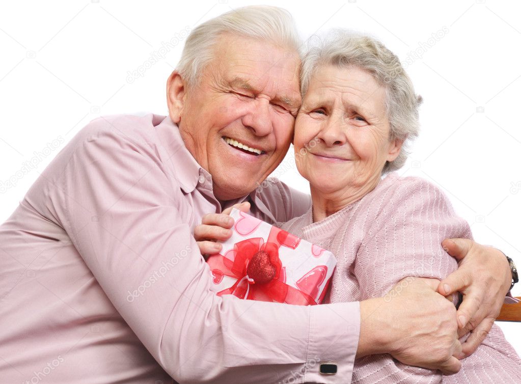Smiling elderly couple and box with gift