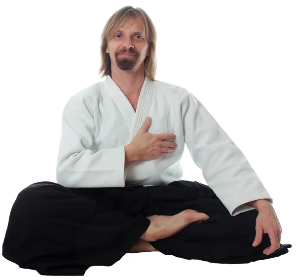 Profesora de pacificación de aikido sentarse en el suelo y poner su mano —  Fotos de Stock