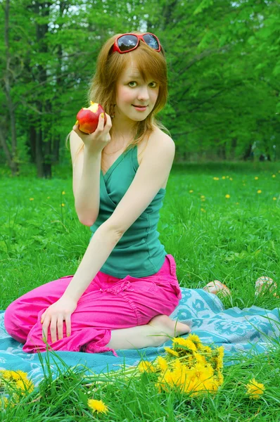 Meisje met apple op coverlet — Stockfoto
