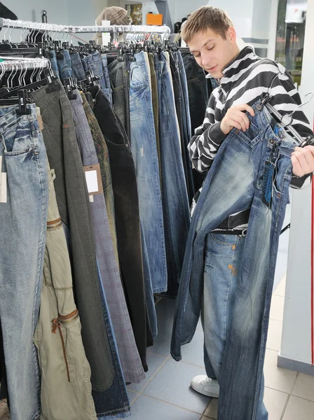 Chłopiec wybór dżinsy w sklepie — Zdjęcie stockowe