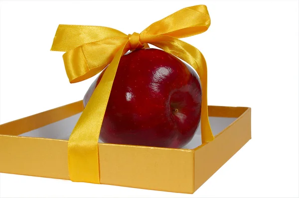 Rött äpple i rutan med gul tejp som gåva — Stockfoto