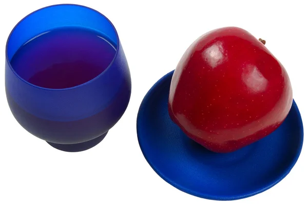 Saftiger Apfel auf blauem Teller und Apfelsaft im blauen Glas — Stockfoto