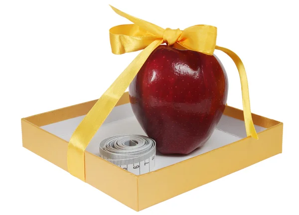 Красное яблоко в коробке с лентой, как подарок — стоковое фото
