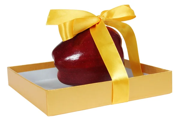 Червоне яблуко в коробці з жовтою стрічкою як подарунок — стокове фото
