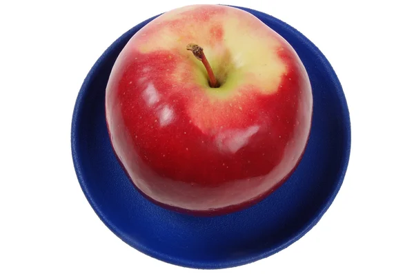 Сочное яблоко на голубом блюде — стоковое фото