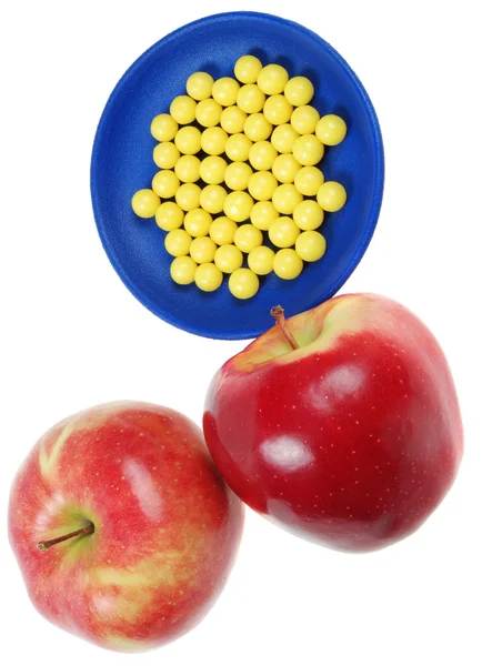 Bord van druppels vitamine en appels boven hen — Stockfoto