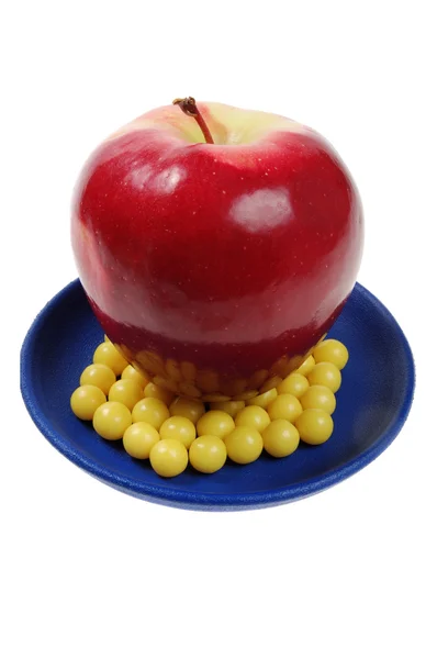 Bord van druppels vitamine en apple boven hen — Stockfoto