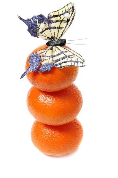 Three mandarins and butterfly on top — Stock Photo, Image