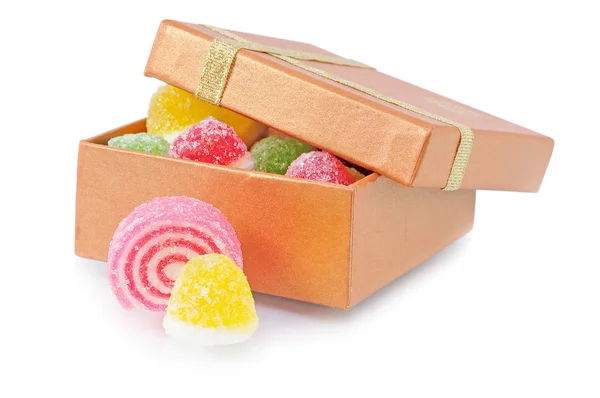 Dvě sladké cukroví leží poblíž box s bonbóny — Stock fotografie