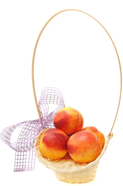 Nectarines in basket with bow — Stock Photo, Image