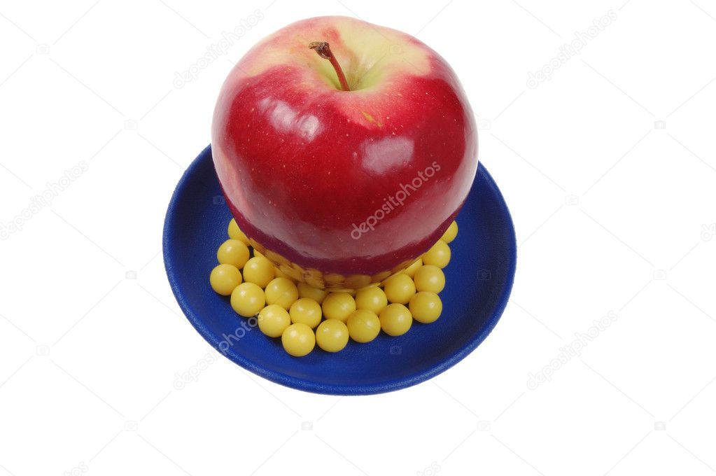Plateful of drops vitamin and apple above them