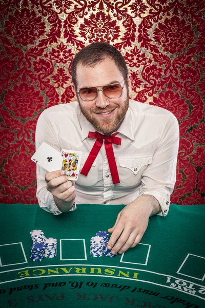 Man Playing Blackjack Holds Up Winning Hand