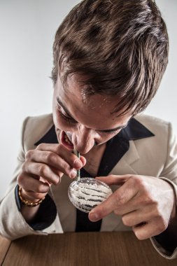 Young White Male Drug User Snorting Cocaine in Suit clipart