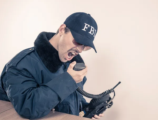 Furieux FBI homme vêtu d'une veste bleue, lunettes de soleil sur la radio vintage — Photo