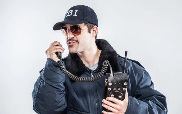 Commanding situation FBI agent in blue jacket talking over vintage radio — Stock Photo, Image