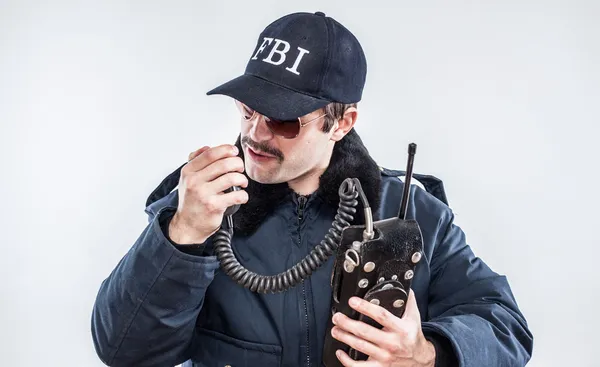 Head down FBI agent in blue jacket talking over vintage radio — Stock Photo, Image