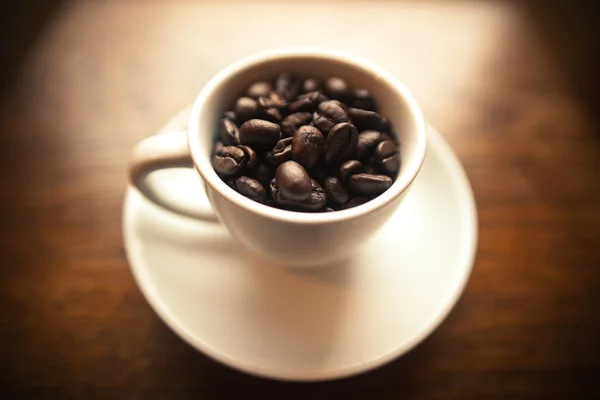 豆でいっぱい白いコーヒーのマグカップ — ストック写真