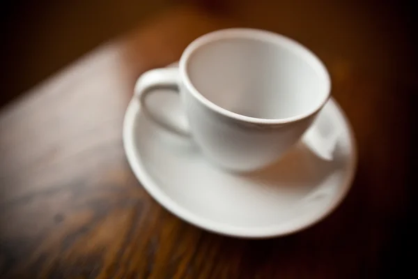 Белая кофейная кружка на белой тарелке — стоковое фото