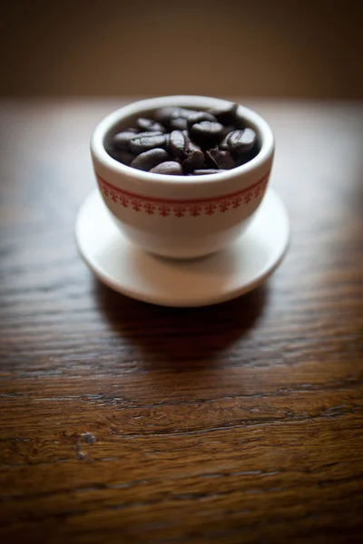 赤のデザインを持つ白いプレート上の白いコーヒーのマグカップ — ストック写真